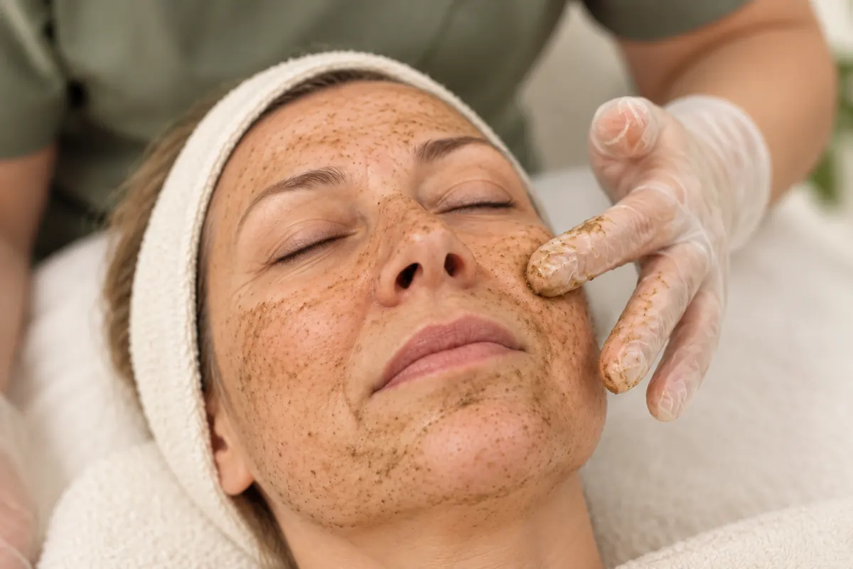 BioMicroneedling-behandeling bij Elim Instituut: een natuurlijke peeling met microkristallen wordt op de wang van een vrouw van rond de 50 gemasseerd.